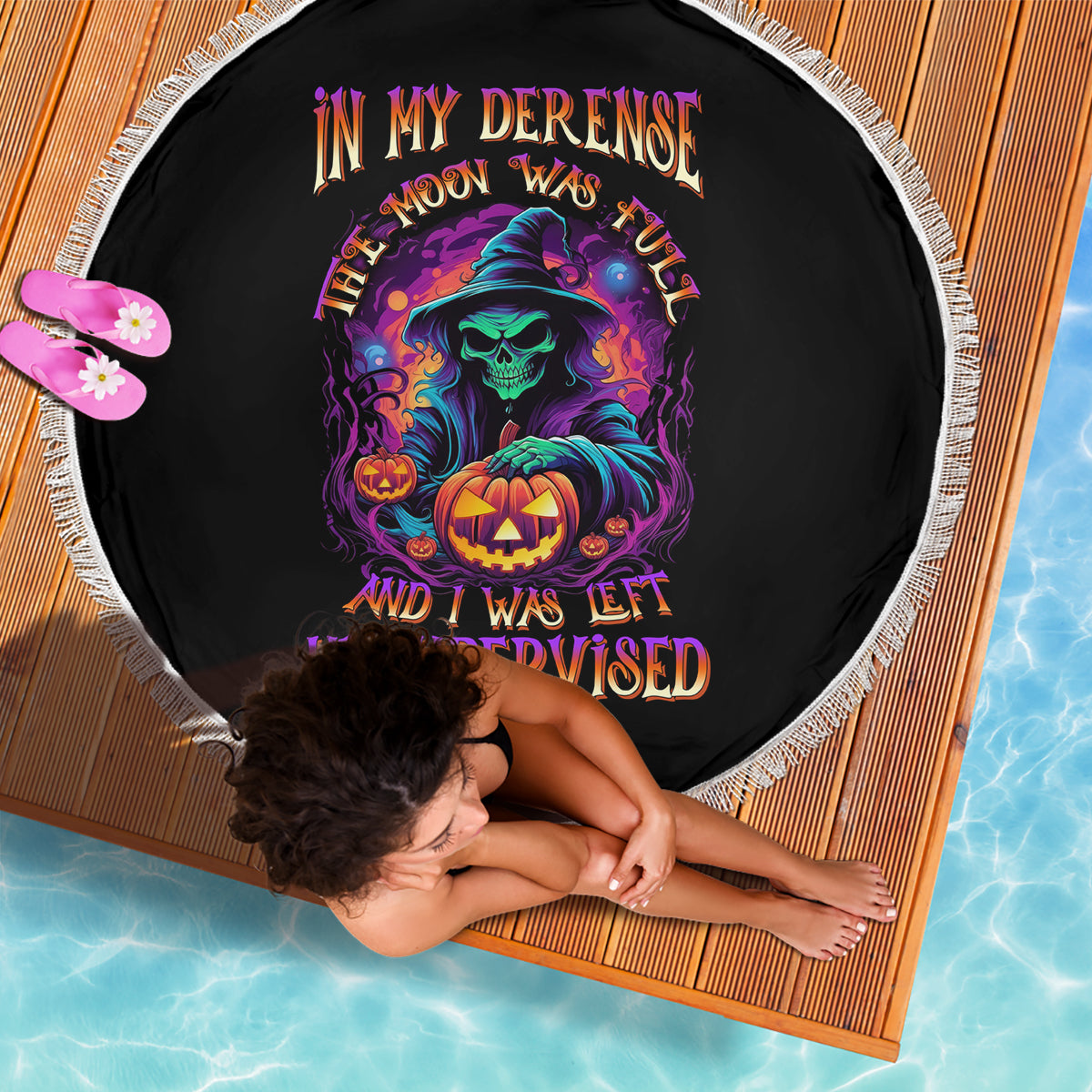 Round black Halloween beach blanket with white fringe edge and colorful skull with pumpkin print