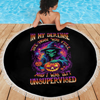 Round black Halloween beach blanket with white fringe edge and colorful skull-pumpkin Halloween graphic