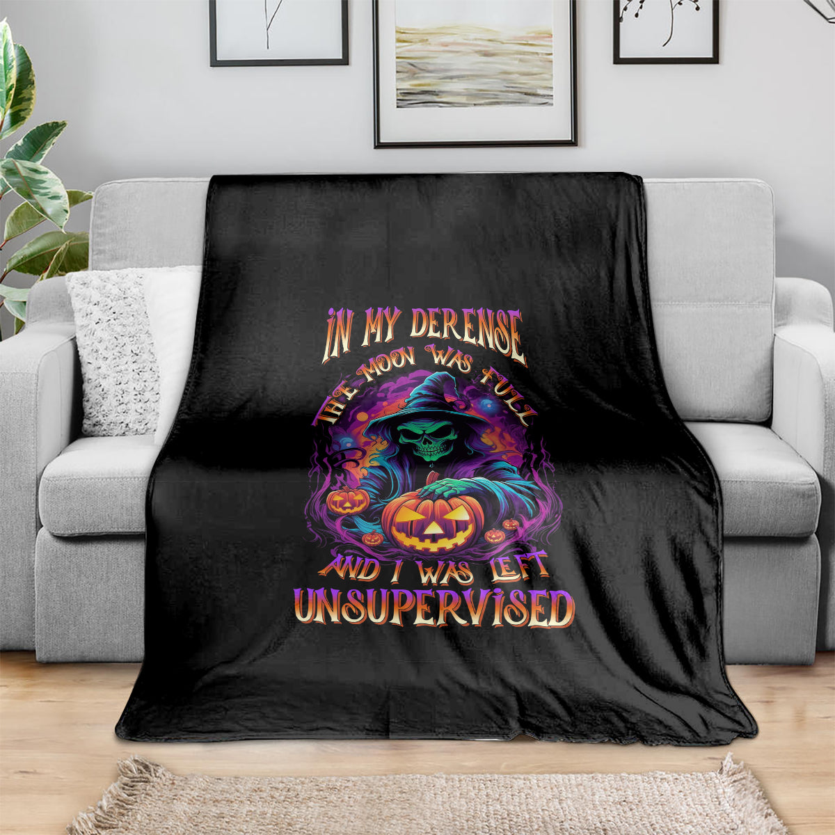 Black Halloween blanket with colorful witch, pumpkin graphic and 'Unsupervised' text