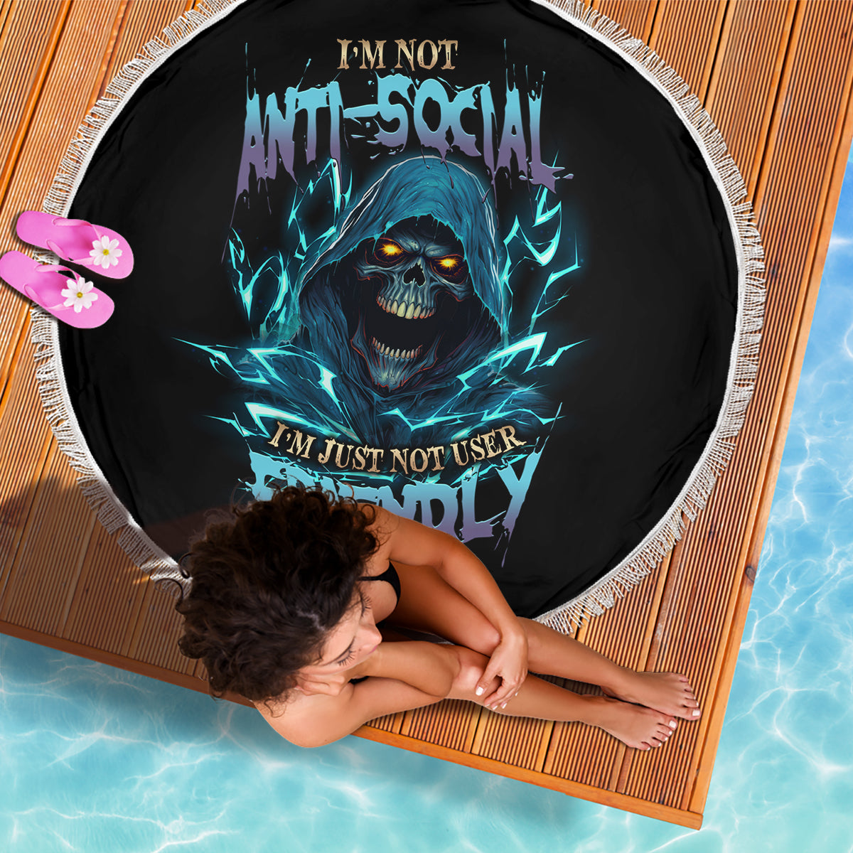 Round beach blanket, black with blue skull graphic and white fringed edge