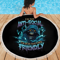 Round beach blanket with blue skull graphic and white fringed border, viewed from back