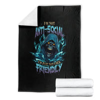 Black skull throw blanket with blue neon text, folded with white blankets