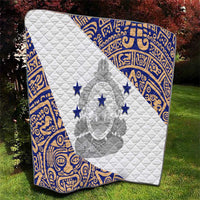 White quilt with blue geometric border, central emblem and five blue stars.