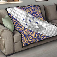 White quilt with blue patterned edges and centered emblem with navy stars, diamond stitch.