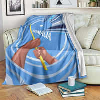 Blue Somalia flag throw blanket with raised fist graphic and Somali text