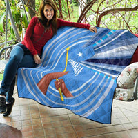 Blue and white Somalia flag quilt laid outdoors, raised fist and spear with star