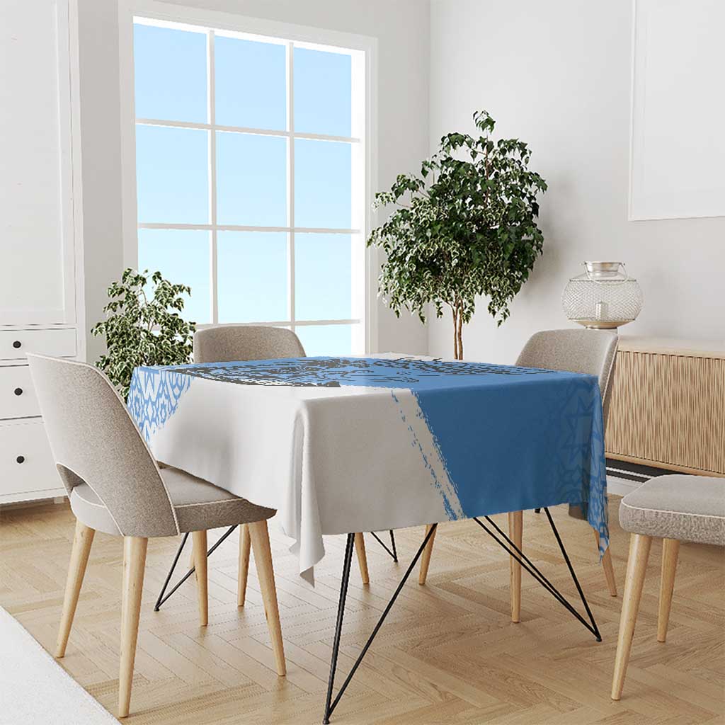 Blue and white tablecloth draped over dining table with geometric border