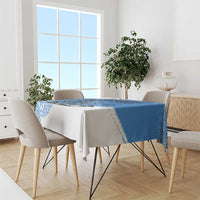 Blue and white tablecloth draped over dining table with geometric border