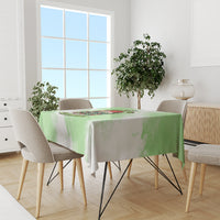 Green Christmas tablecloth draped on round dining table with skull wreath motif