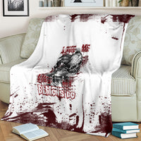 Skull graphic blanket on couch: white with dark red splatter, skull portrait, and “DEMONS DO” text