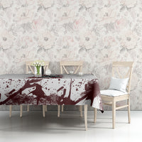 Skull tablecloth with maroon splatter design and dark motif, laid across long table