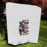 White quilt with diamond stitching and red/black character graphic in the middle