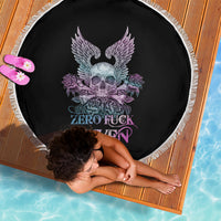 Round black beach blanket with skull, purple wings, roses graphic and fringe edge.