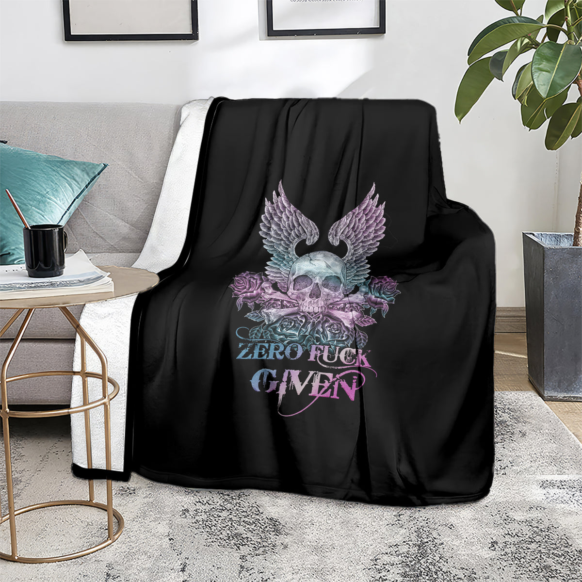 Black decorative blanket with winged skull and rose graphic on a sofa setting