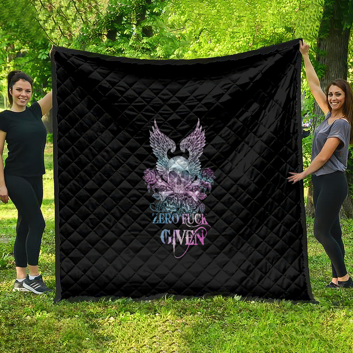 Black quilt with quilted diamond pattern and multicolor skull-wing rose graphic, banner text.