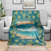 Blue tropical beach blanket draped on gray sofa, showing Bahamas wordmark and palms