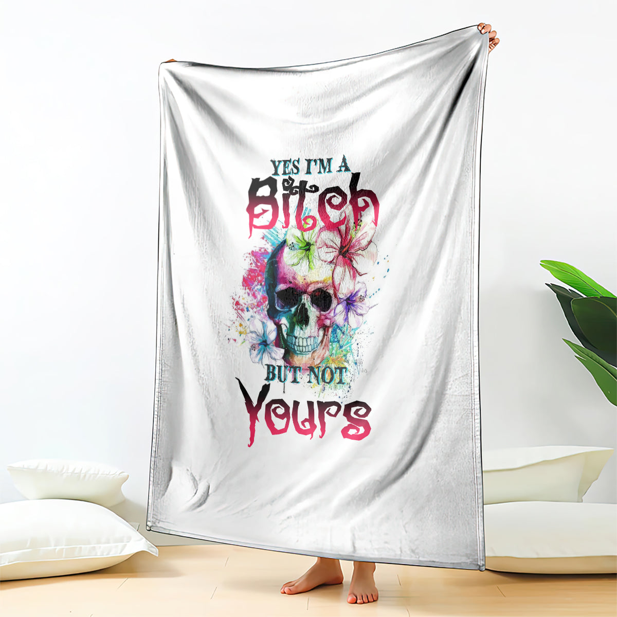 White blanket hanging display with colorful skull graphic and bold slogan text