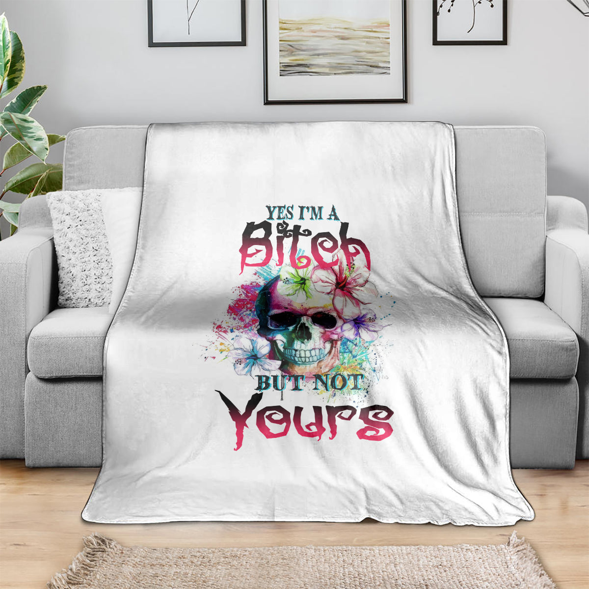 White throw blanket with colorful skull graphic and bold slogan text