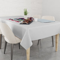 Light gray tablecloth on dining table with folded corner drape and multicolor graphic