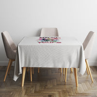 Light gray tablecloth with small multicolor graphic at center, draped on square table