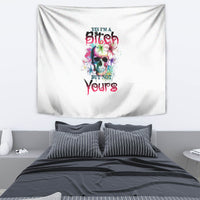 Multicolor skull graphic tapestry with bold text, hanging above a bed