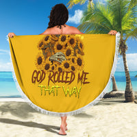 Round yellow beach blanket held up on beach, skull and sunflower graphic with white fringe