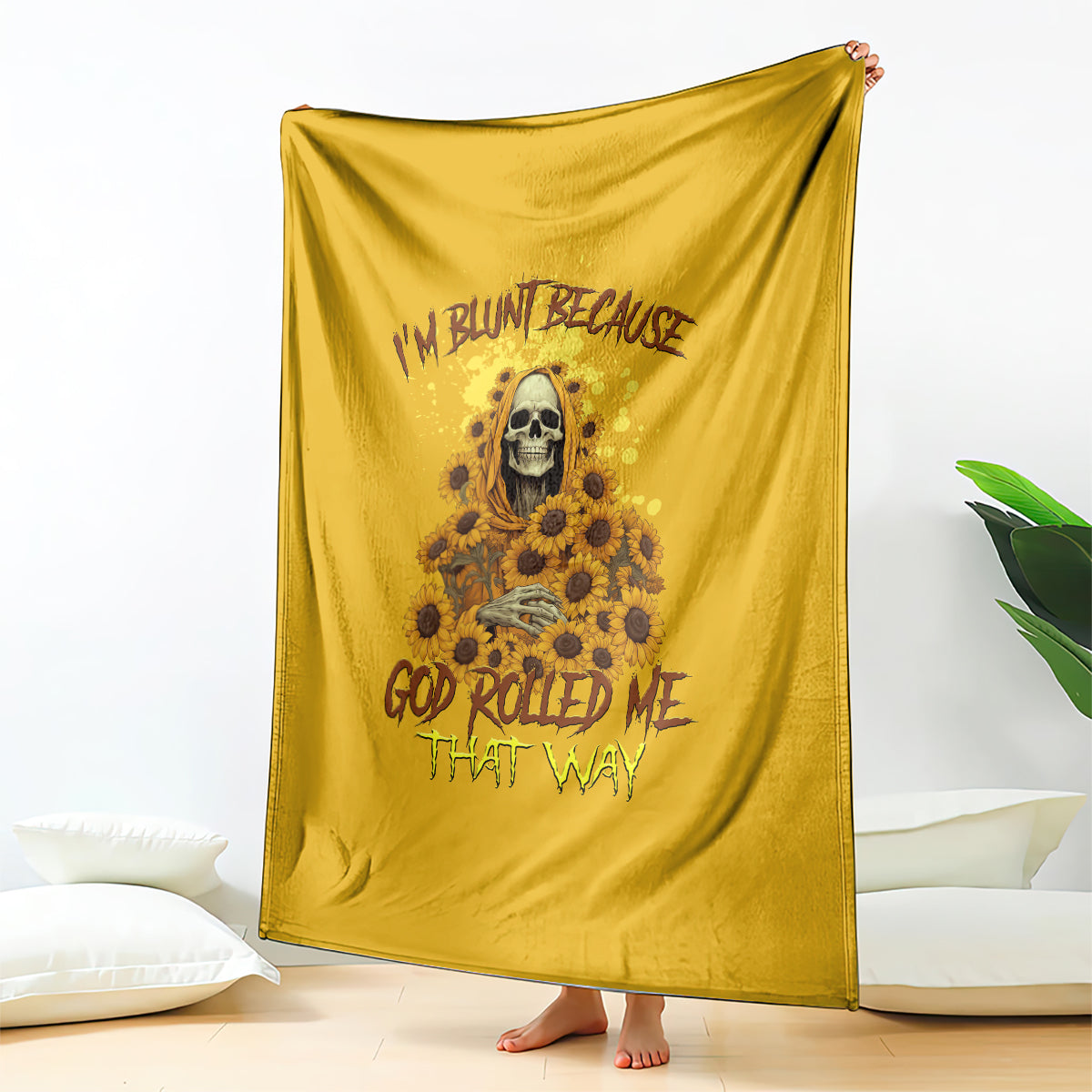 Golden yellow reaper throw blanket with skull and sunflower floral design, draped