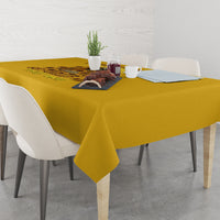 Yellow tablecloth with dark graphic print, draped across a dining table