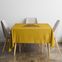 Yellow tablecloth with dark center graphic, set on a dining table with chairs