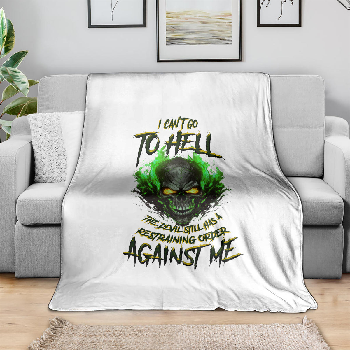 White skull graphic blanket with green fire-eyed skull and claw-text design