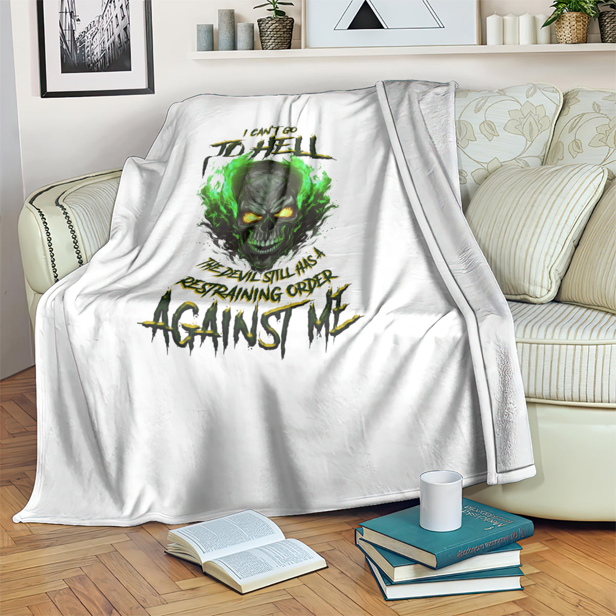 White skull graphic blanket folded on couch, green fire-eyed skull with text