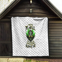 White quilted blanket displayed on wall, showing green skull graphic and lettering