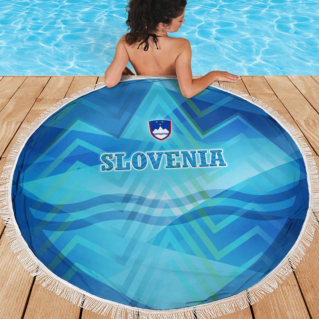 Round blue beach blanket with white fringe, SLOVENIA text and crest, alpine pattern
