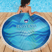 Round blue beach blanket with white fringe, SLOVENIA text and crest, alpine pattern