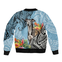 Cyan bomber jacket with black ribbed hem, greyhound portrait, floral accents and Polynesian motifs