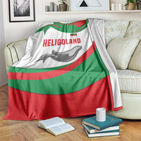 Green red white blanket with HELIGOLAND text and seal graphic, draped over a couch