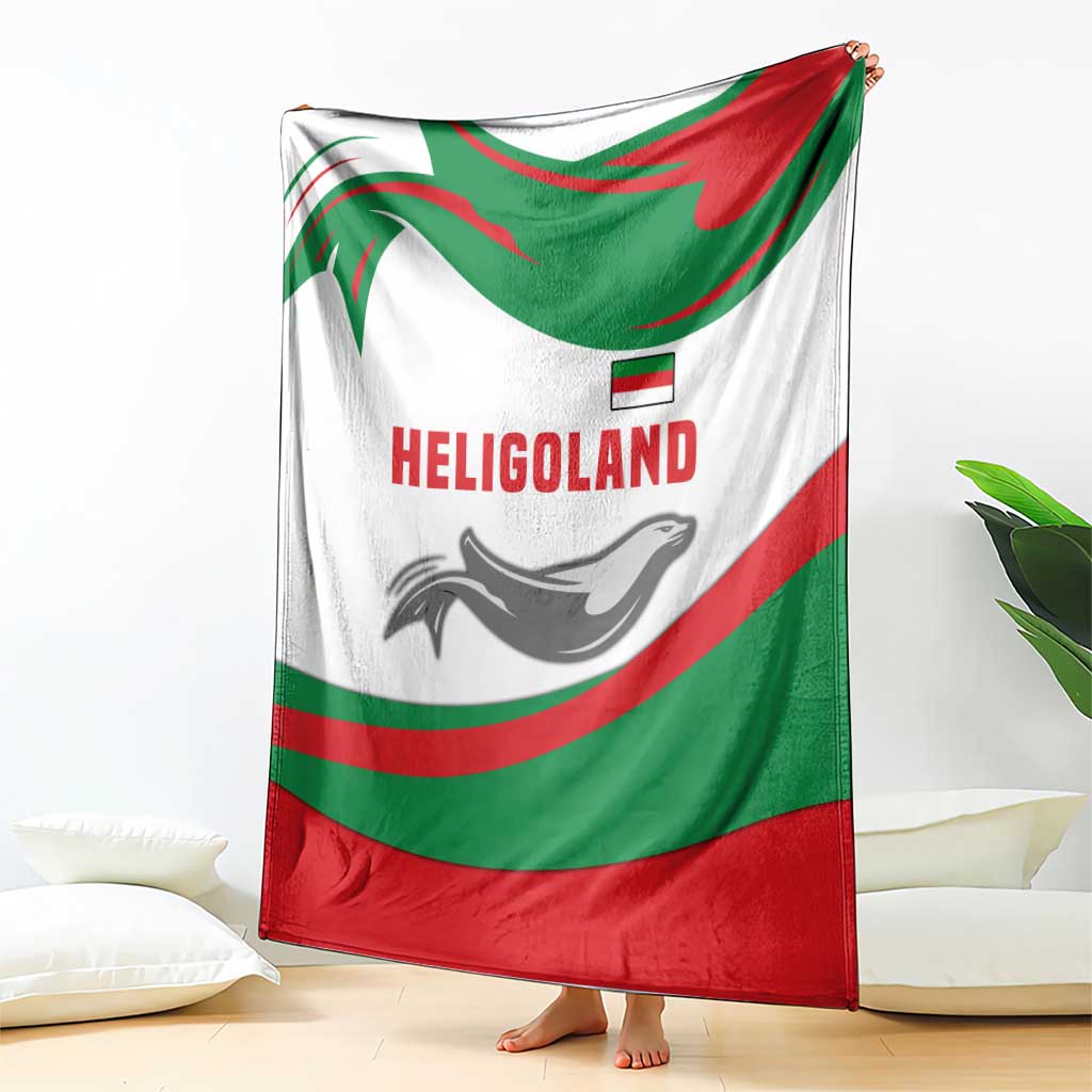White green red blanket with HELIGOLAND wordmark and seal graphic, hanging over legs