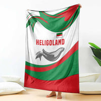 White green red blanket with HELIGOLAND wordmark and seal graphic, hanging over legs