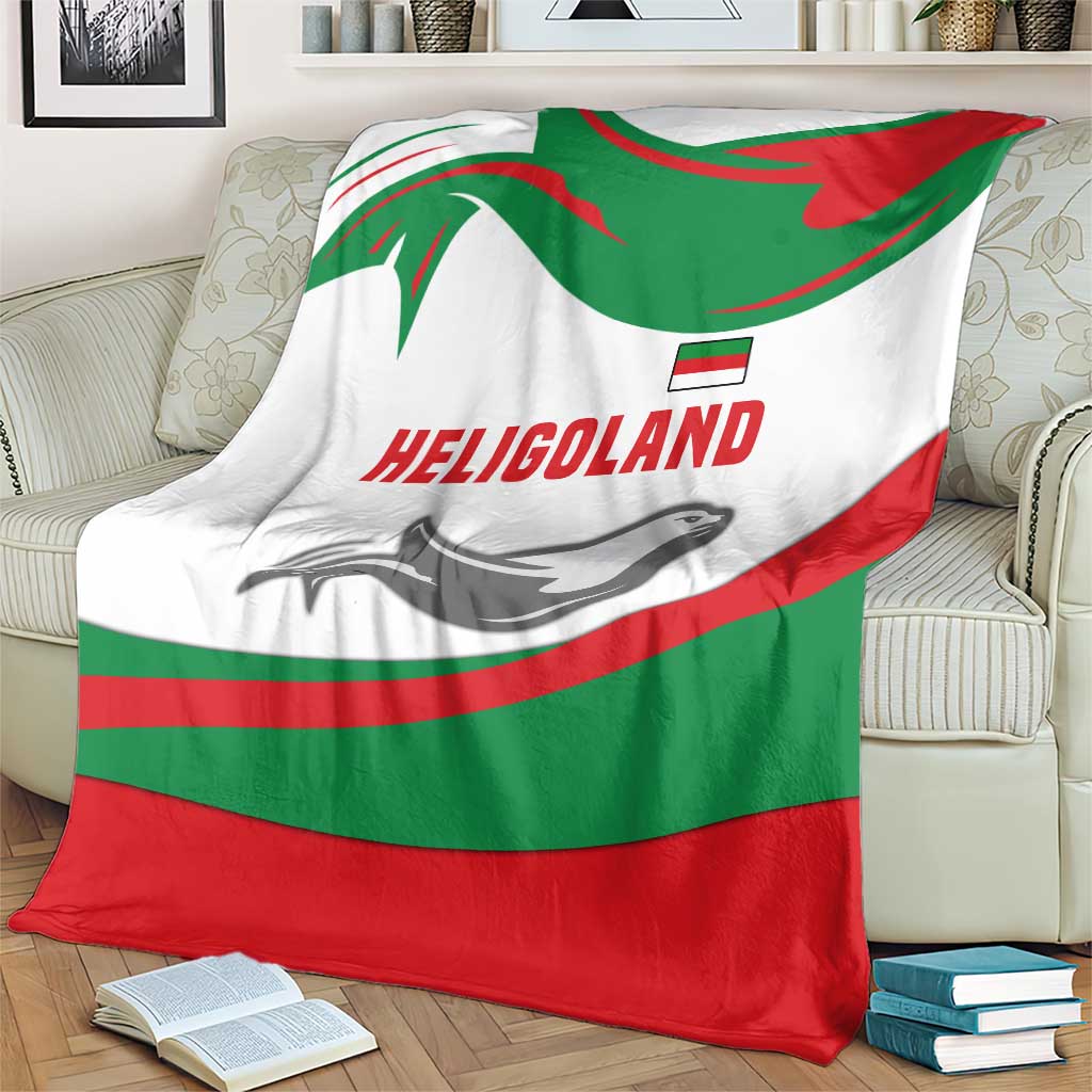 Green red white blanket with HELIGOLAND text and seal graphic, folded on an armchair