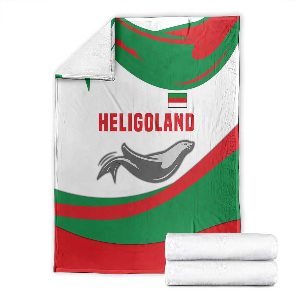 Green red white blanket with HELIGOLAND text and seal graphic, shown with stacked white rolls