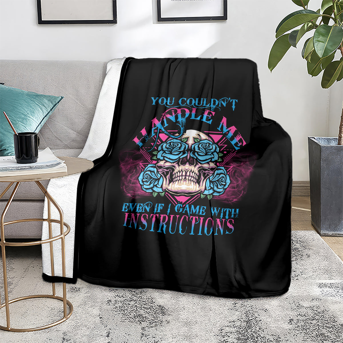 Black triangle skull graphic blanket with blue and magenta roses, draped on couch