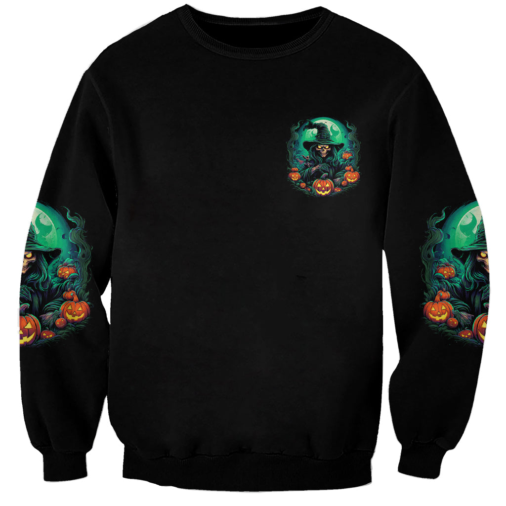 Unisex black Halloween sweatshirt with small green witch emblem and pumpkin sleeve prints