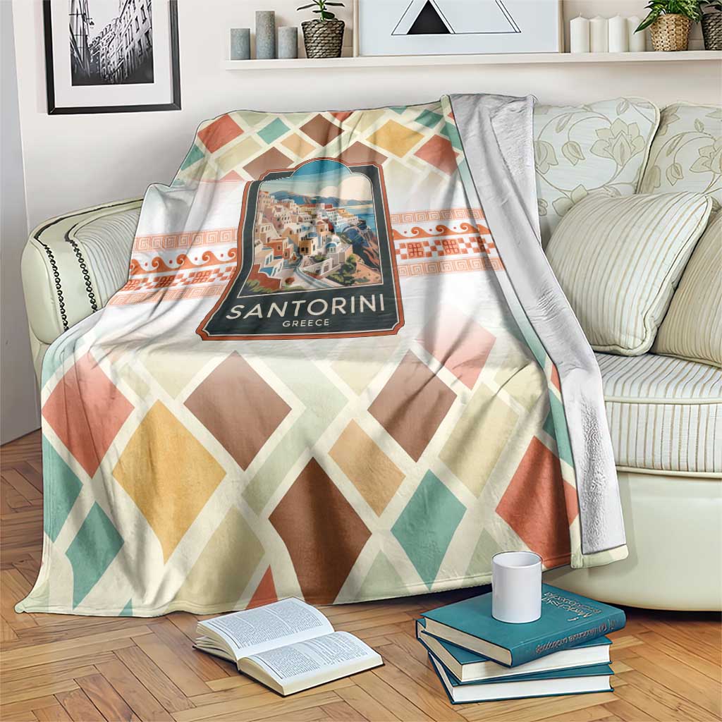 Multicolor travel blanket with geometric diamond pattern and Santorini village emblem