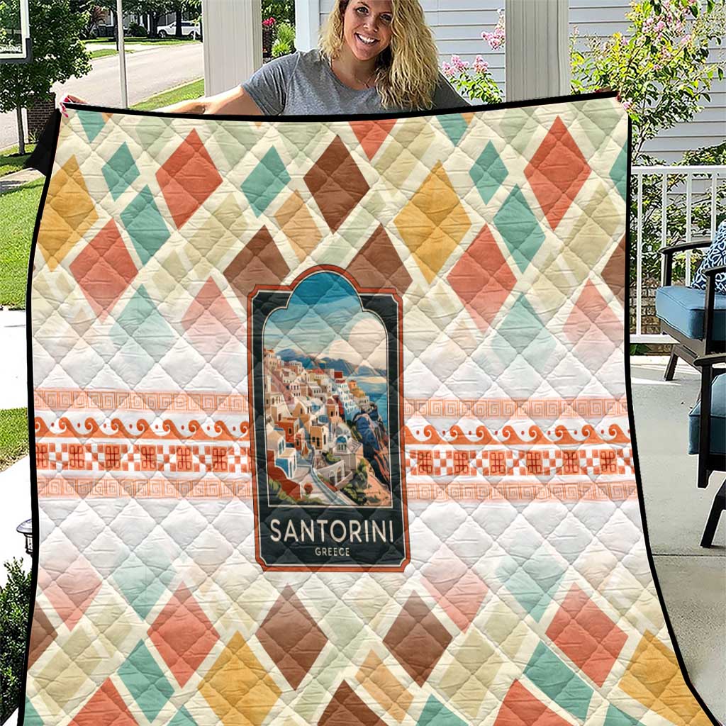 Quilt blanket with diamond pattern, orange border, and Santorini scene emblem patch