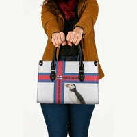 White leather tote bag with black handles, red and blue cross stripe, puffin print