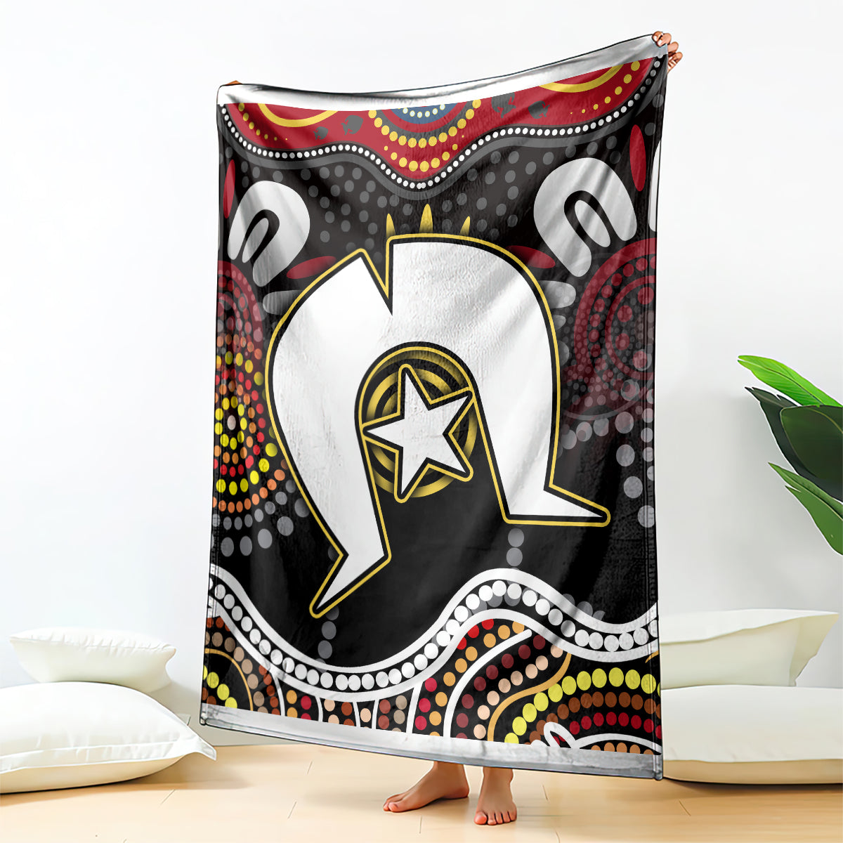 Multicolor Aboriginal pattern blanket draped on floor, black-and-red circular design