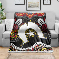 Multicolor Aboriginal pattern blanket on gray sofa with large white-and-black animal graphic