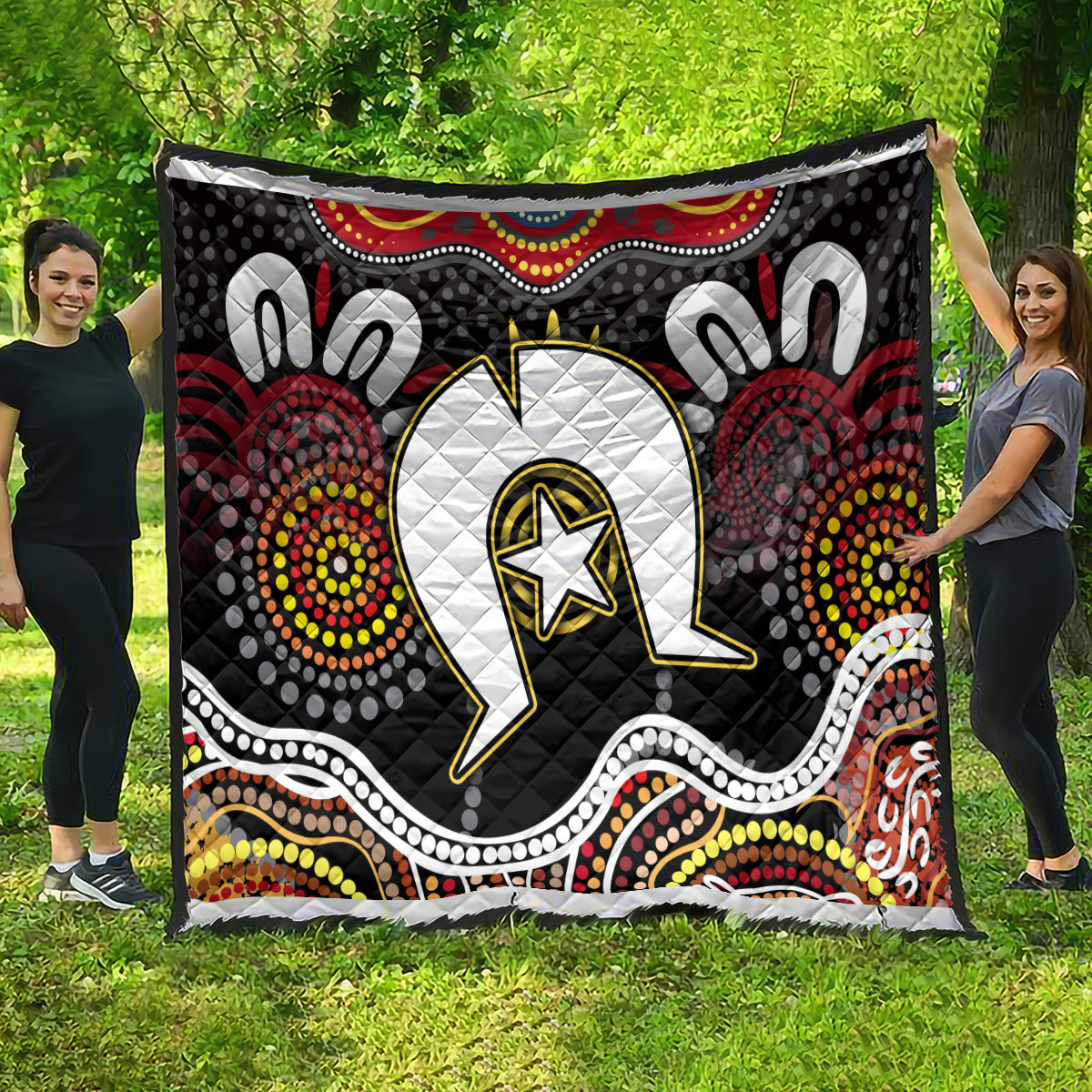 Multicolor Aboriginal pattern quilt with central white emblem and black dotted medallions