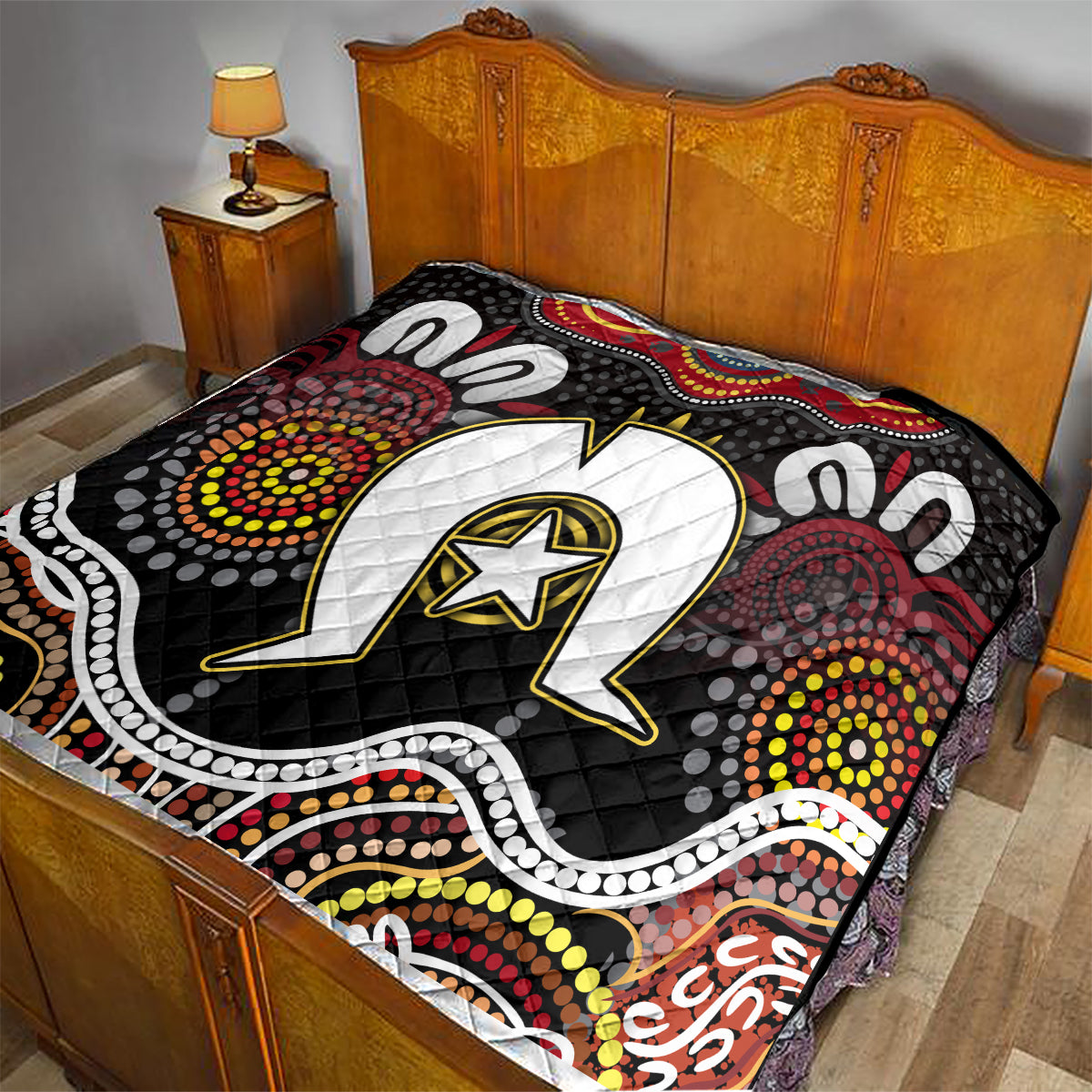 Black Aboriginal pattern quilt covering a bed, featuring white star emblem and dot clusters