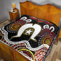 Black Aboriginal pattern quilt covering a bed, featuring white star emblem and dot clusters